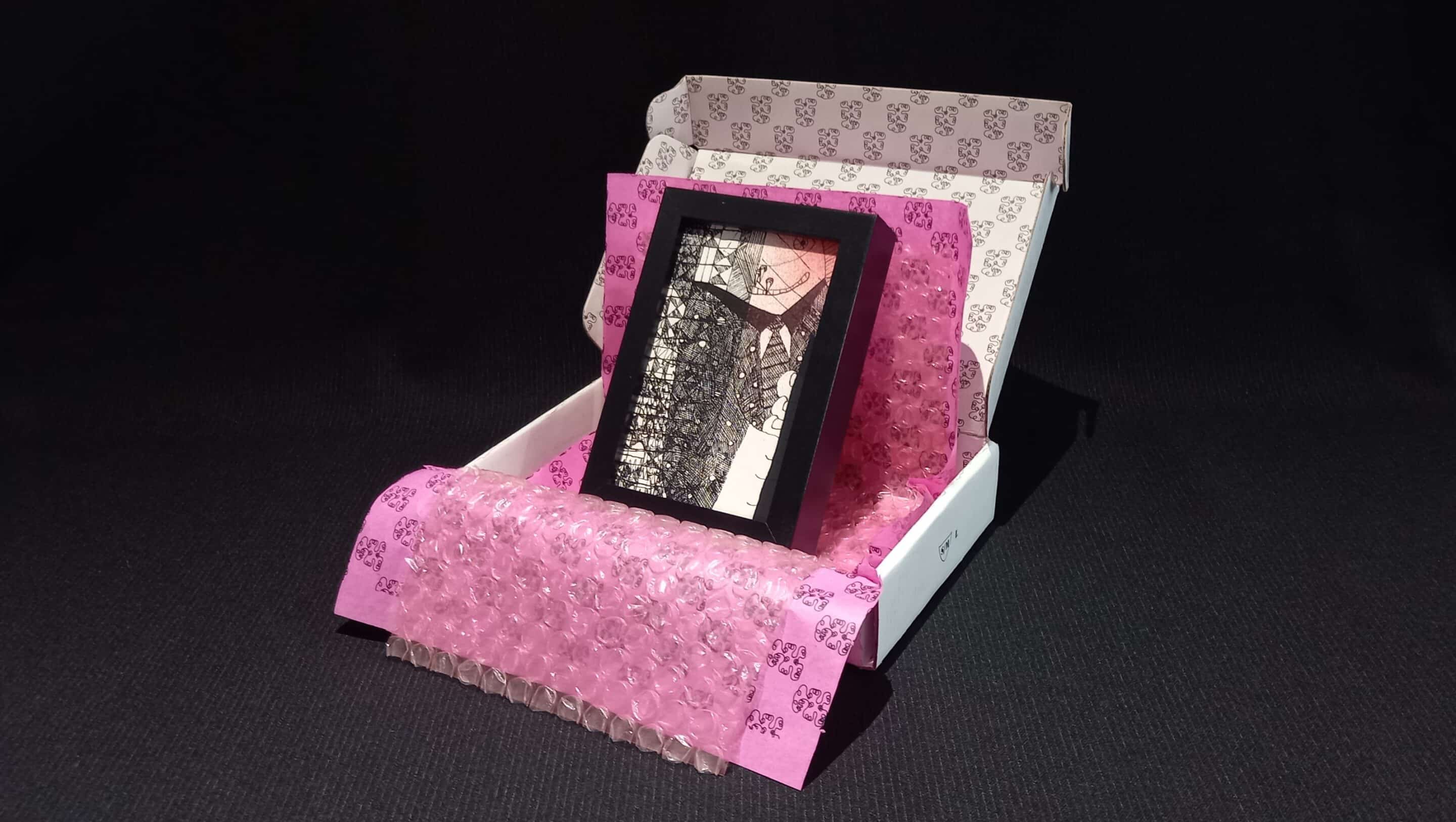 Œuvre encadrée en noir et blanc, sérigraphie unique avec parfois des rehauts de peinture fuchsia. Emballage soigné : papier bulle, papier de soie, et boîte en carton double cannelure décorée à la main en sérigraphie.