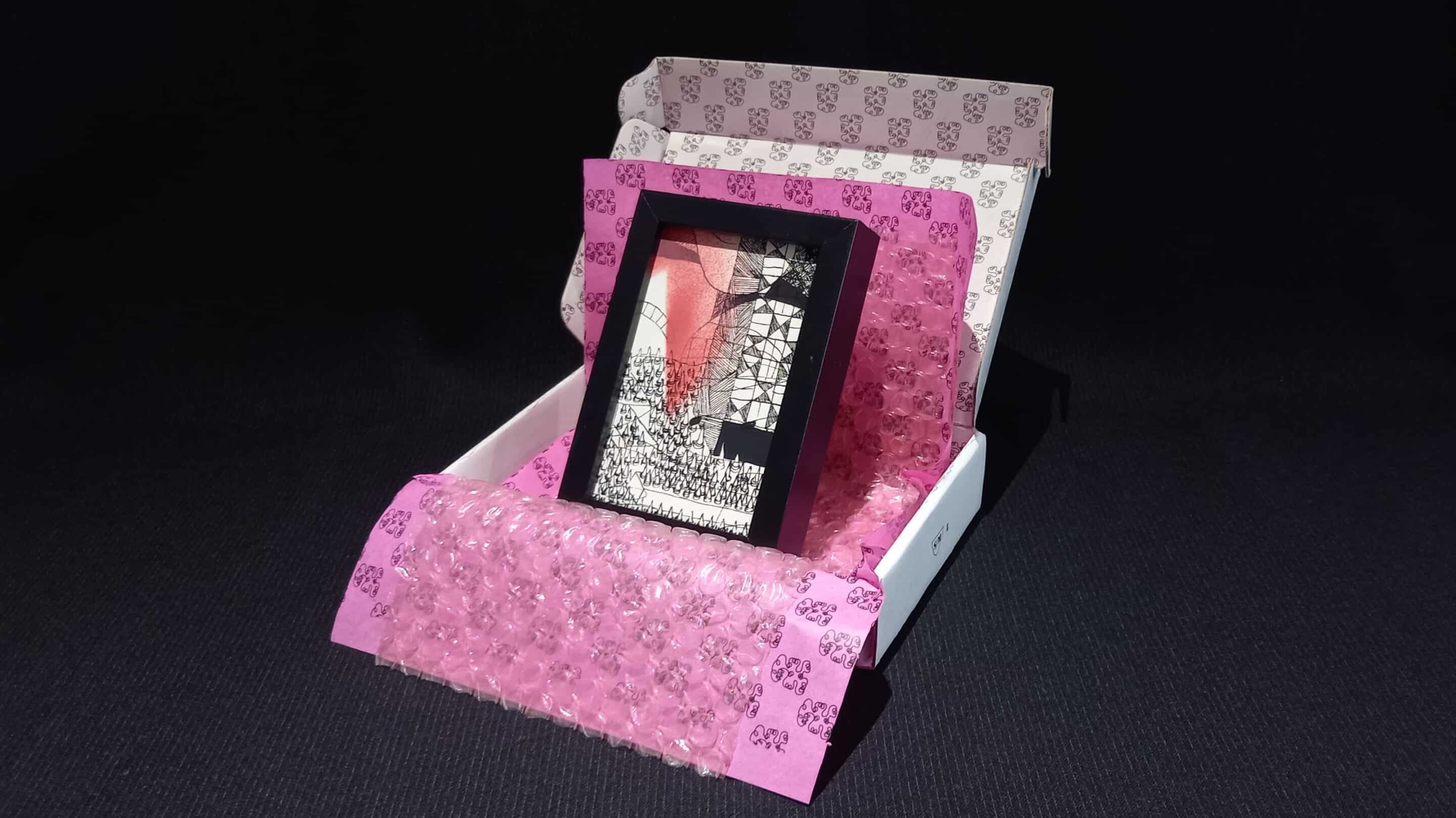 Œuvre encadrée en noir et blanc, sérigraphie unique avec parfois des rehauts de peinture fuchsia. Emballage soigné : papier bulle, papier de soie, et boîte en carton double cannelure décorée à la main en sérigraphie.