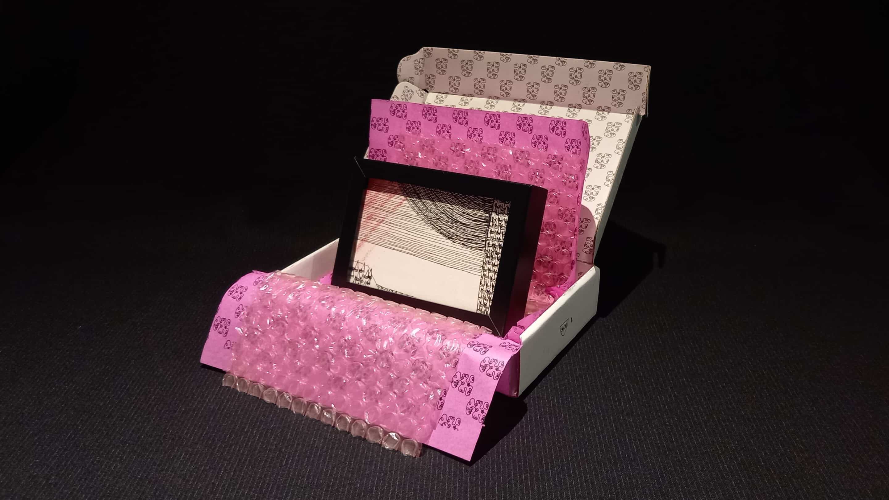 Œuvre encadrée en noir et blanc, sérigraphie unique avec parfois des rehauts de peinture fuchsia. Emballage soigné : papier bulle, papier de soie, et boîte en carton double cannelure décorée à la main en sérigraphie.