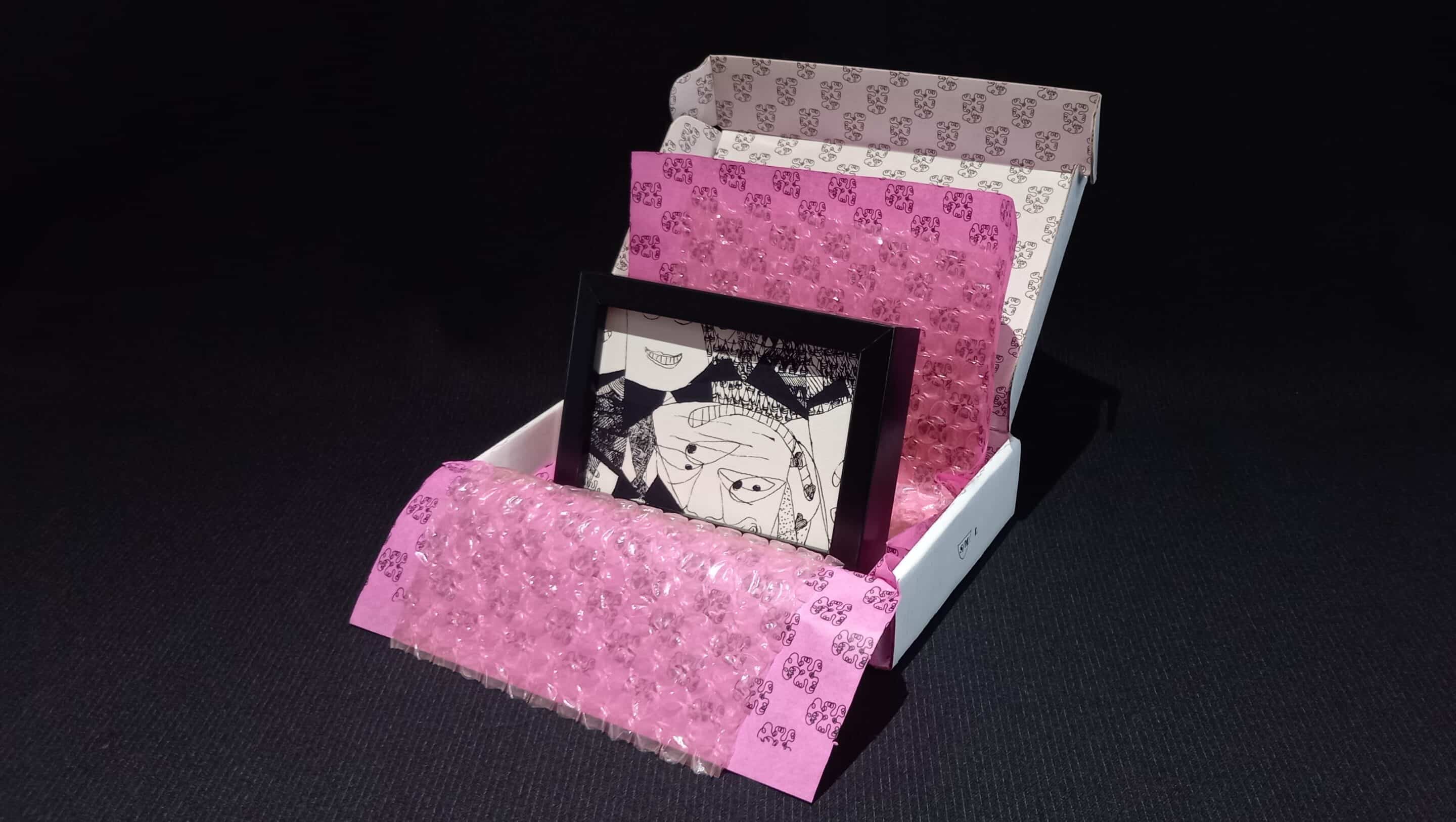 Œuvre encadrée en noir et blanc, sérigraphie unique avec parfois des rehauts de peinture fuchsia. Emballage soigné : papier bulle, papier de soie, et boîte en carton double cannelure décorée à la main en sérigraphie.