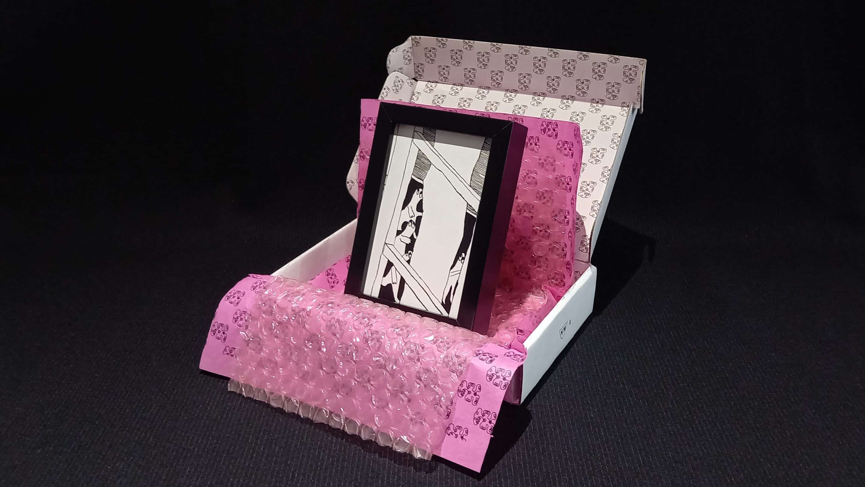 Œuvre encadrée en noir et blanc, sérigraphie unique avec parfois des rehauts de peinture fuchsia. Emballage soigné : papier bulle, papier de soie, et boîte en carton double cannelure décorée à la main en sérigraphie.
