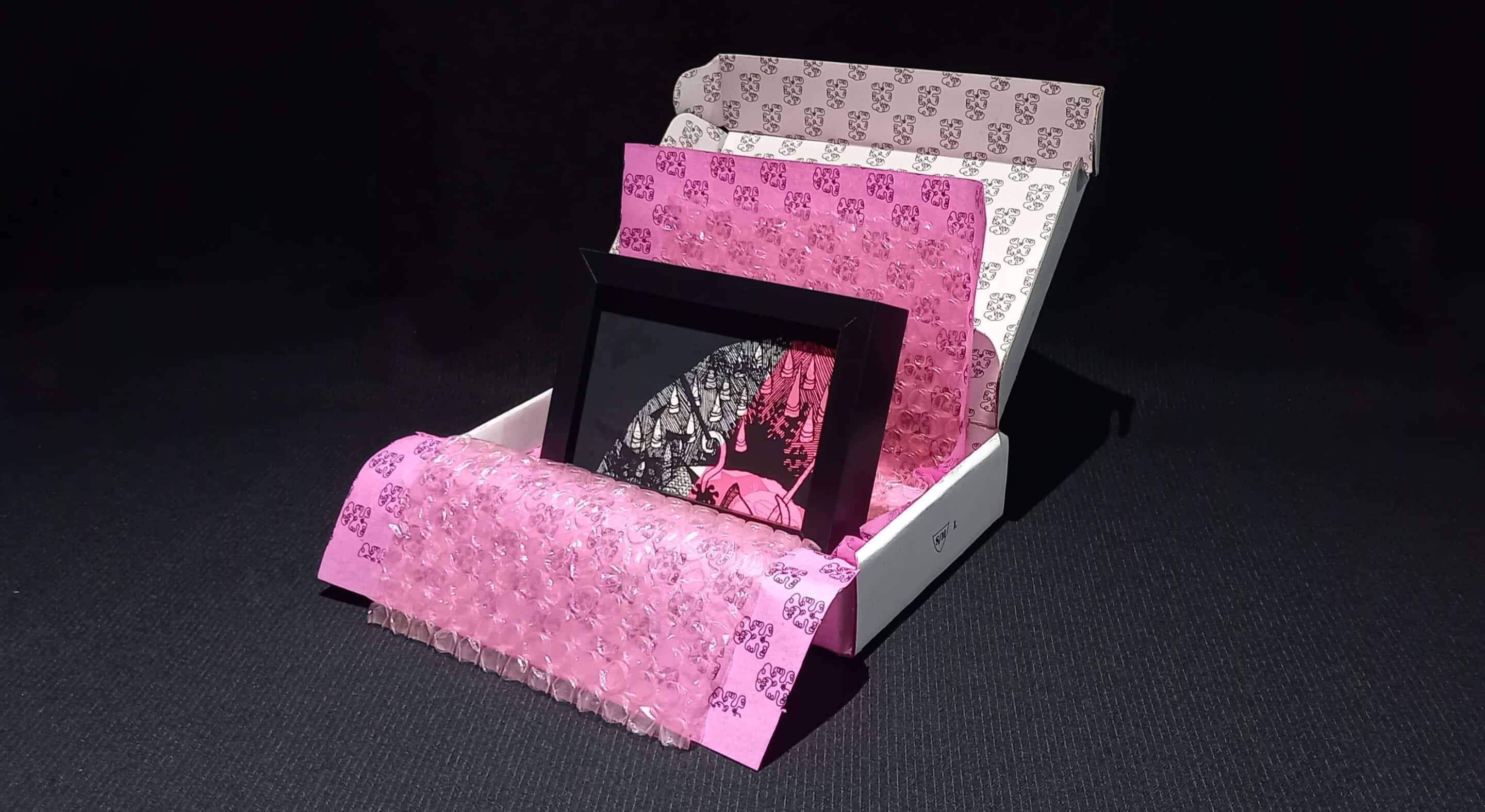 Œuvre encadrée en noir et blanc, sérigraphie unique avec parfois des rehauts de peinture fuchsia. Emballage soigné : papier bulle, papier de soie, et boîte en carton double cannelure décorée à la main en sérigraphie.
